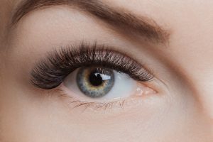 Eyelash extension procedure. Beautiful female eyes with long lashes, closeup